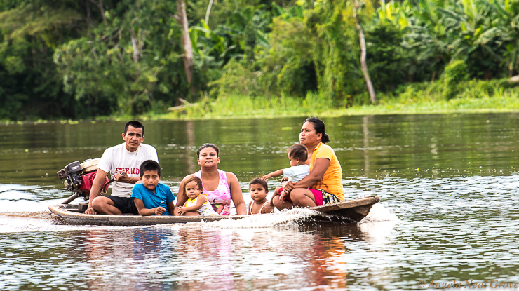 Amazon River Life: Borderd by dense jungle, the Amazon River is a superhighway. It is only link with the outside world for families living in the headwaters region. Here a family of seven is crammed into a small dugout canoe with an outboard motor.//Photo: ANGROVE