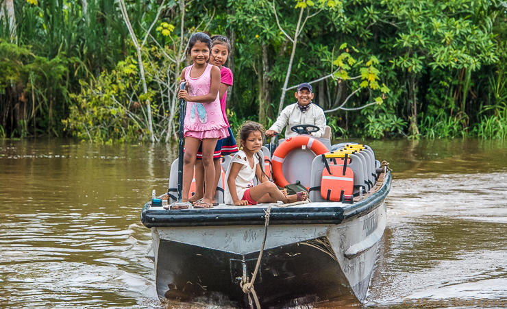 Amazon River Life: A guide gives a ride on a small skiff to some village children of the Amazonas Community. //PHOTO ANGROVE
